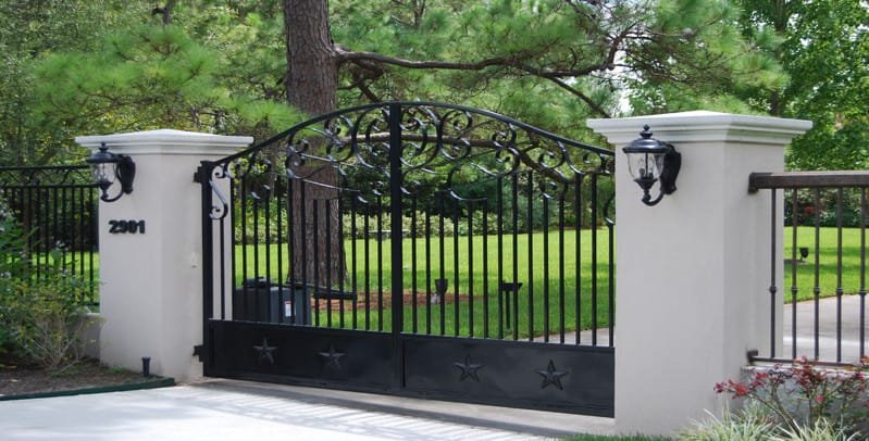 wrought iron gate surrounded by white pillars